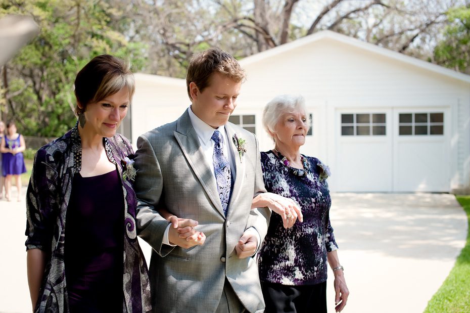 groom walking his mother and grandmother down aisle wedding